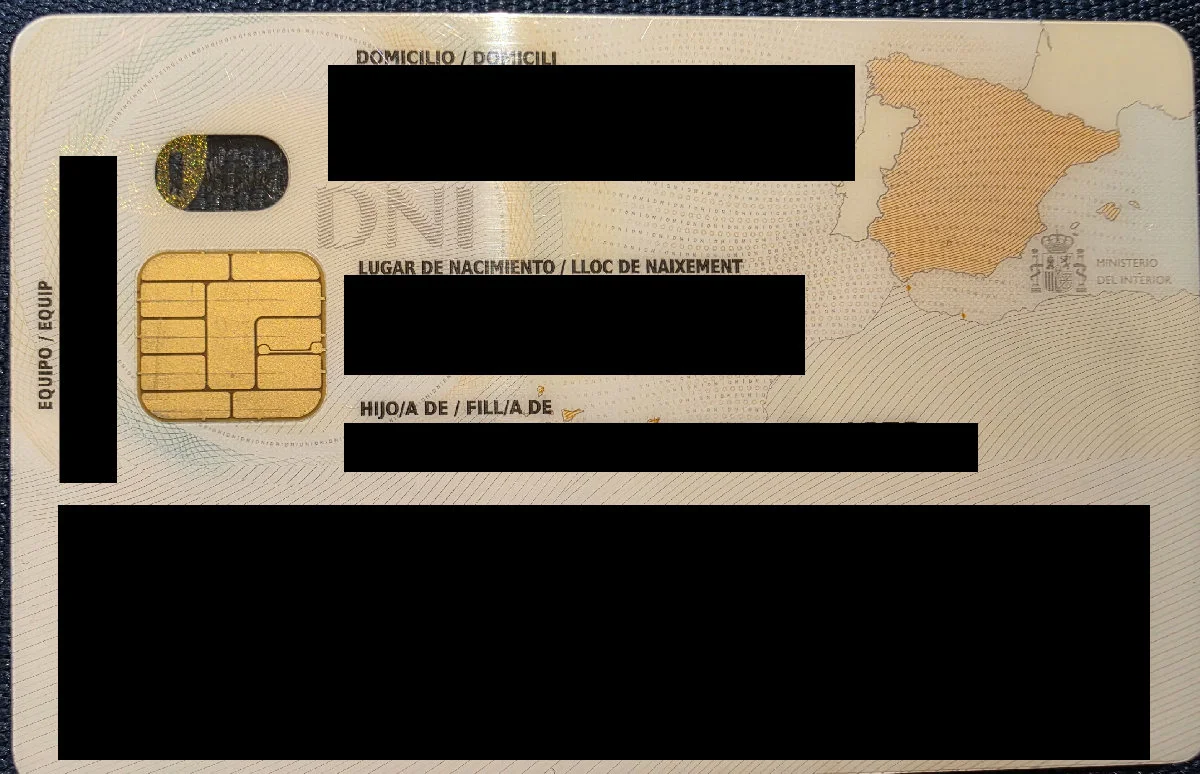 Reverso de un DNI real con domicilio, nacimiento, progenitores y MRZ tapados con barras negras